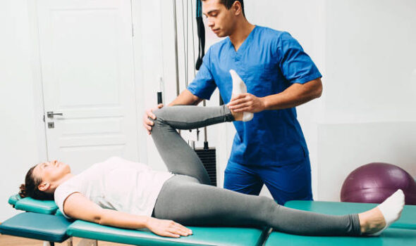 physiotherapist doing leg muscle stretching to the patient. Treatment of a woman's sciatic nerve
